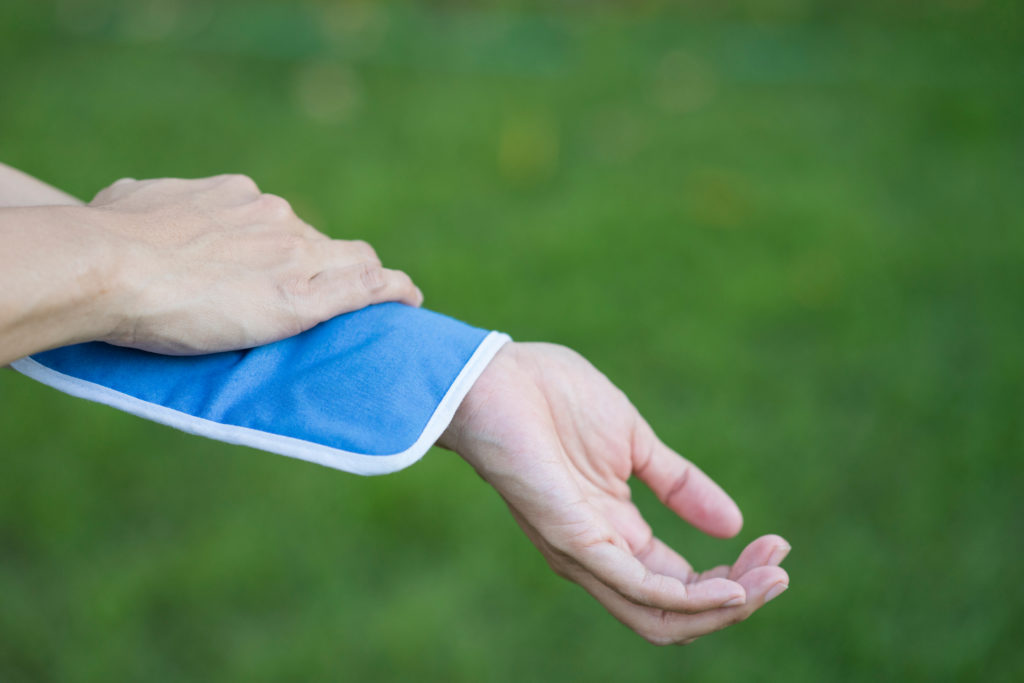 Canva woman putting an ice pack on her arm pain