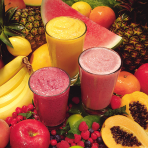 Colorful fruit smoothies in glasses with fresh fruits around them